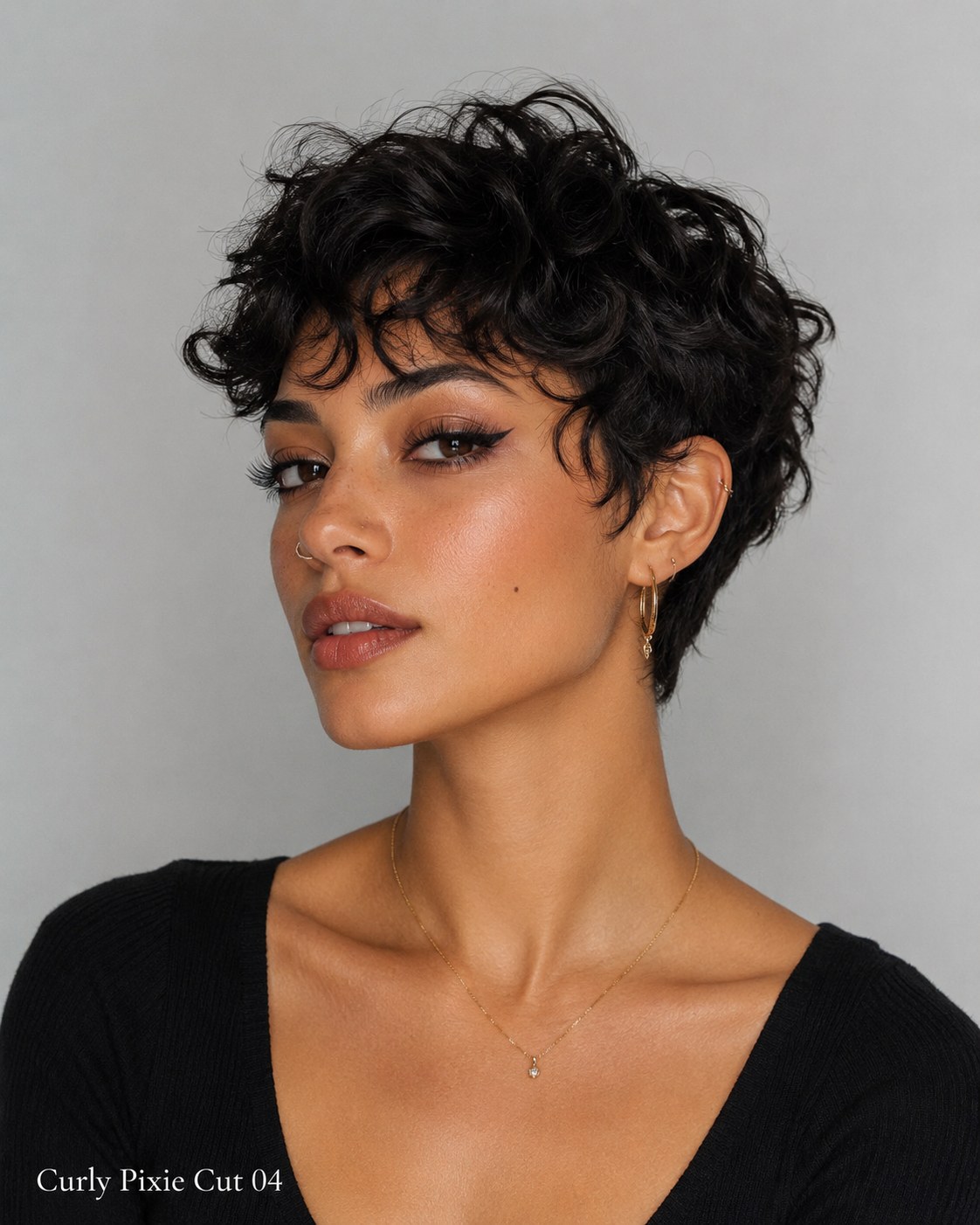 Longer curly pixie cut styled with a side-swept fringe for a sculpted finish