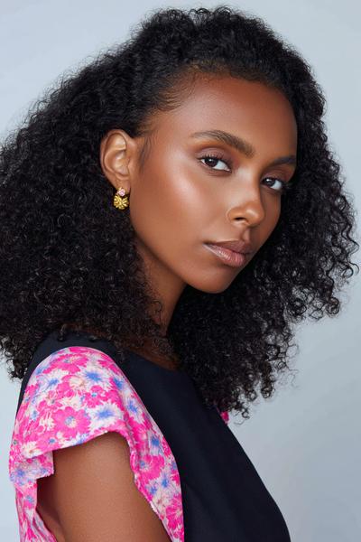 2. Sleek Low Puff for Hairstyles for School Curly Hair Tied Up with a Middle Part and Edge Control