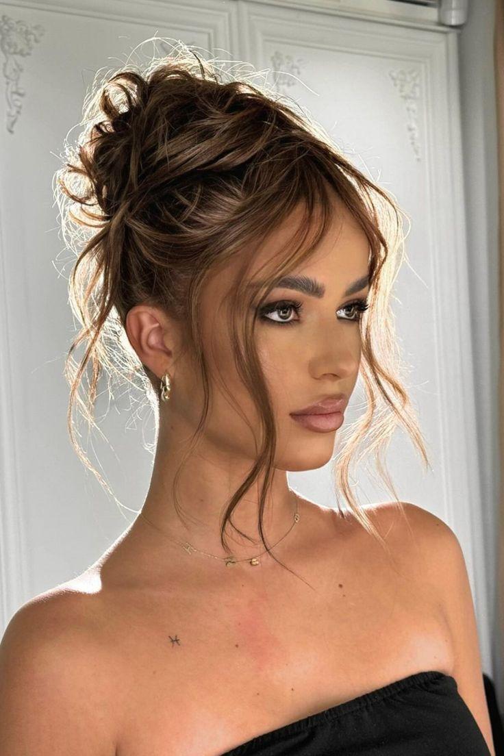 Messy 90s bun with curtain bangs