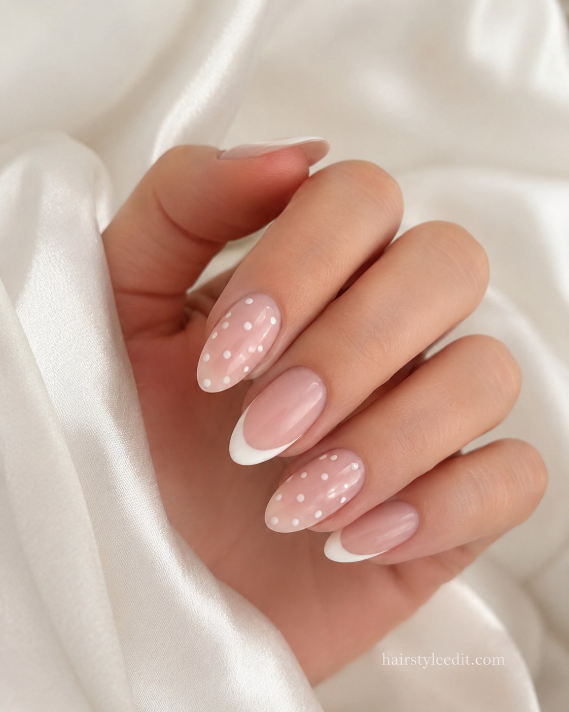 Almond short nails with white French tips and scattered white polka dots on pink base