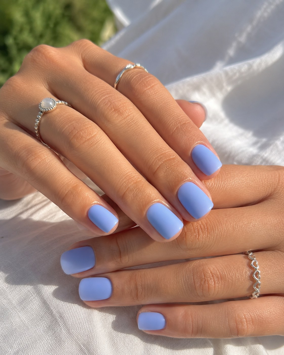 Short square shellac nails painted in a solid opaque periwinkle blue