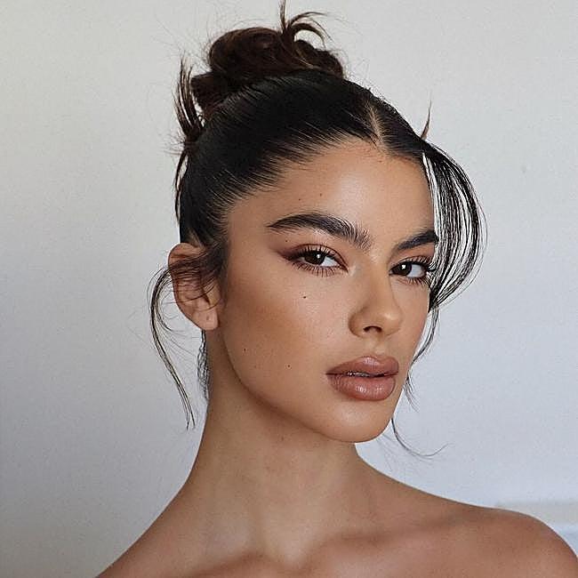 Loose curl messy high bun updo with tendrils
