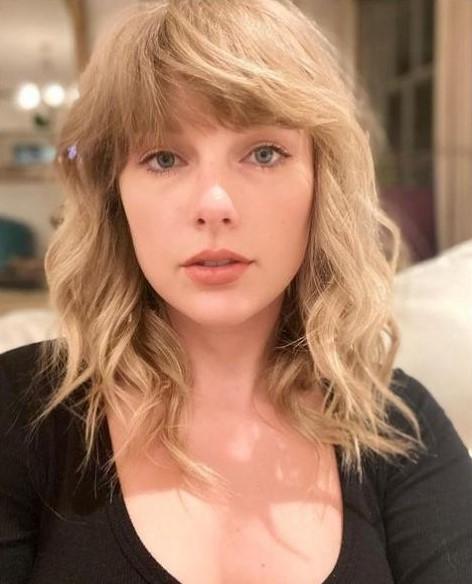 Taylor Swift curtain bangs wavy hairstyle